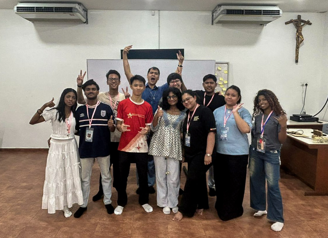 Facilitators and confirmands posing together indoors